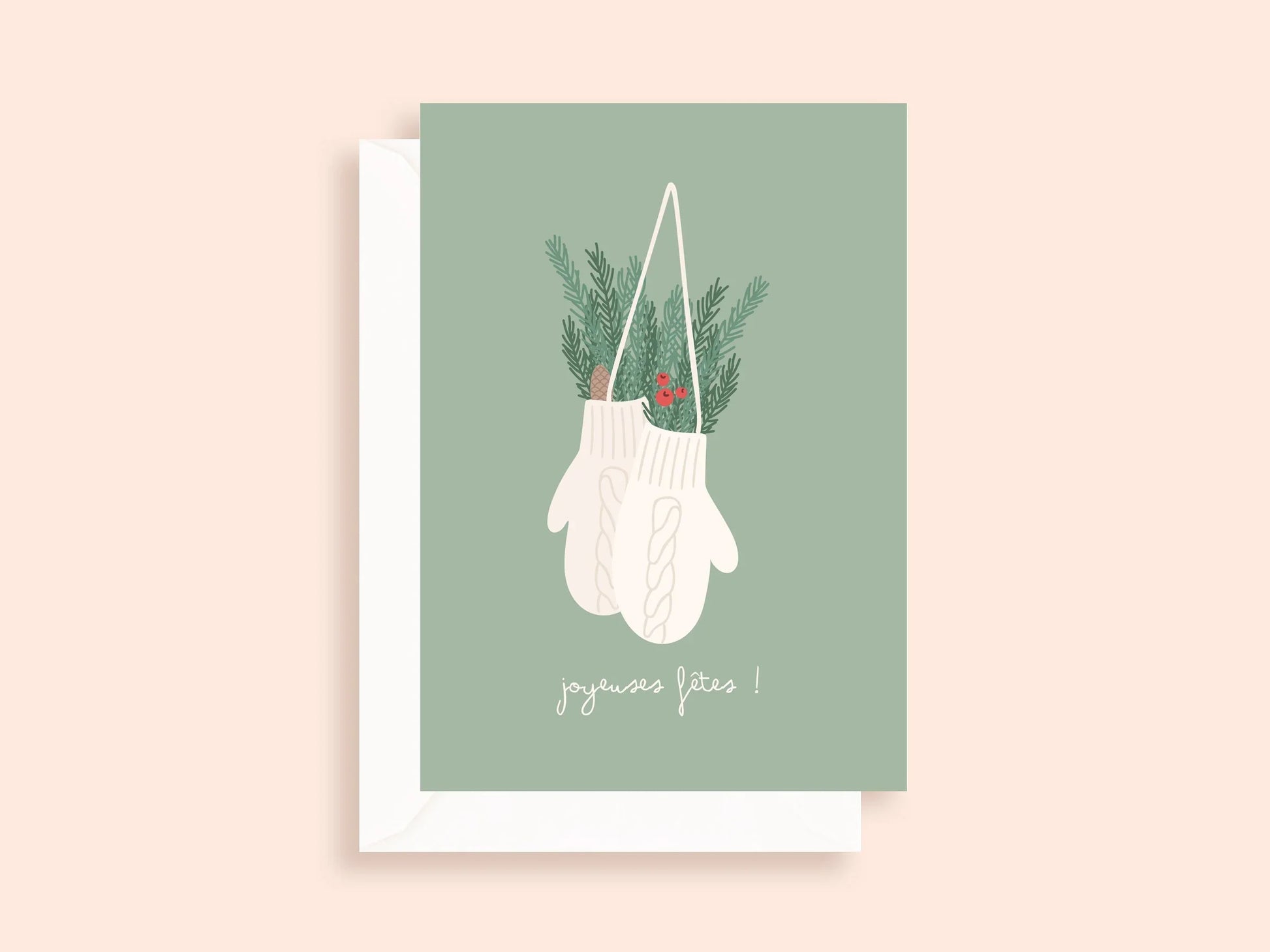 Carte de vœux avec gants de laine blancs suspendus, décorations de pin et baies rouges, fond vert