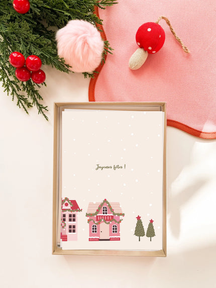 Carte de vœux de Noël avec village décoré et texte Joyeuses fêtes, décorations rouges et vertes