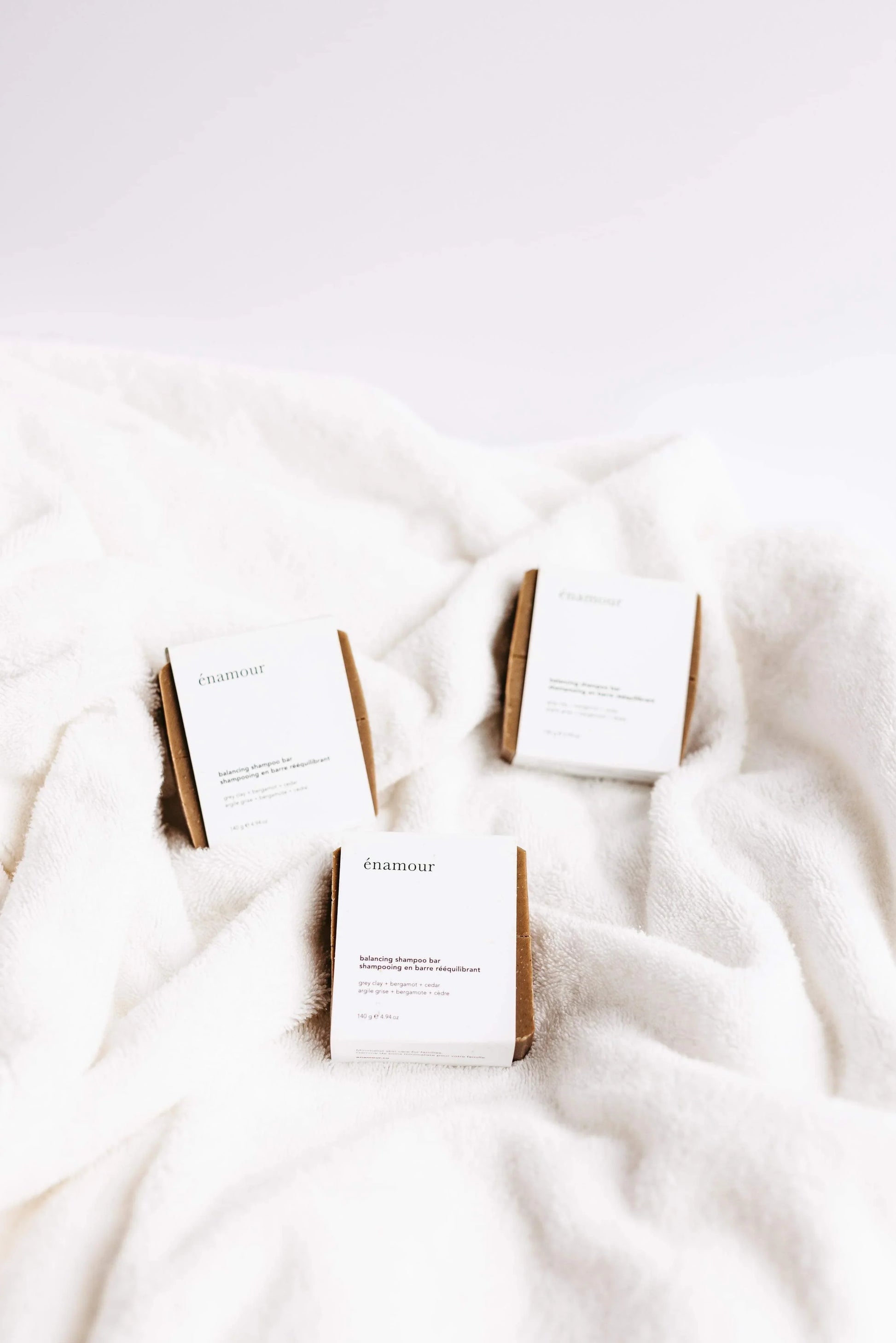 Trois barres de shampooing équilibrant énamour sur tissu blanc doux