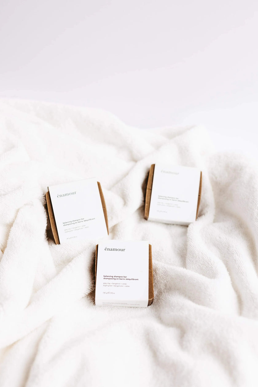 Trois barres de shampooing équilibrant énamour sur tissu blanc doux