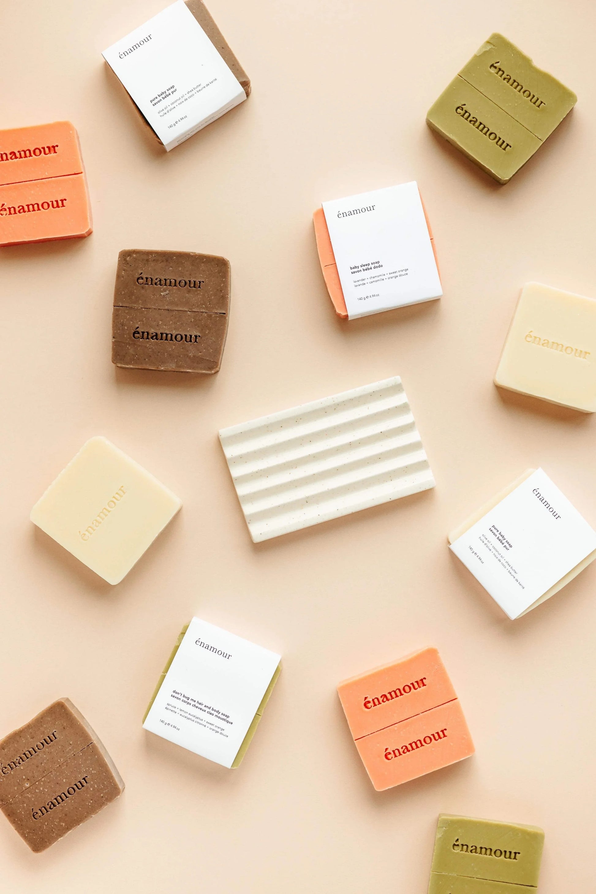 Barres de savon carrées énamour aux couleurs naturelles et emballages blancs sur fond beige