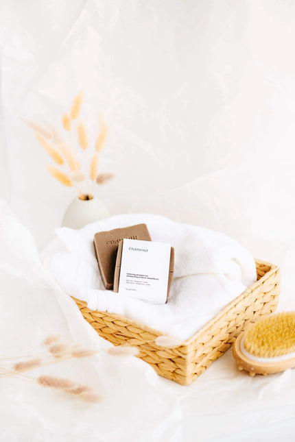 Panier en osier avec serviette blanche et shampooing solide énamour, décor minimaliste naturel