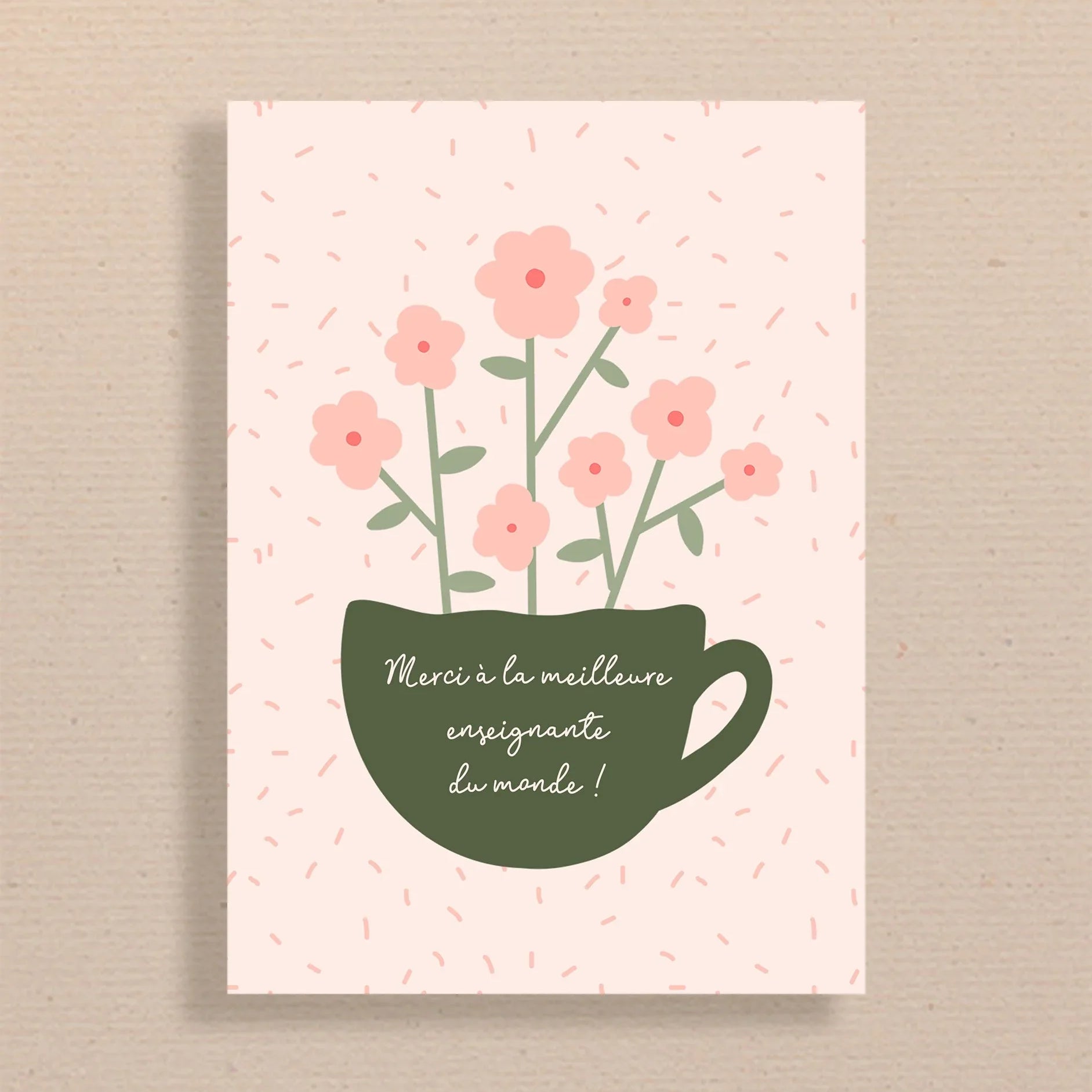 Carte avec tasse verte et fleurs roses, texte Merci à la meilleure enseignante du monde