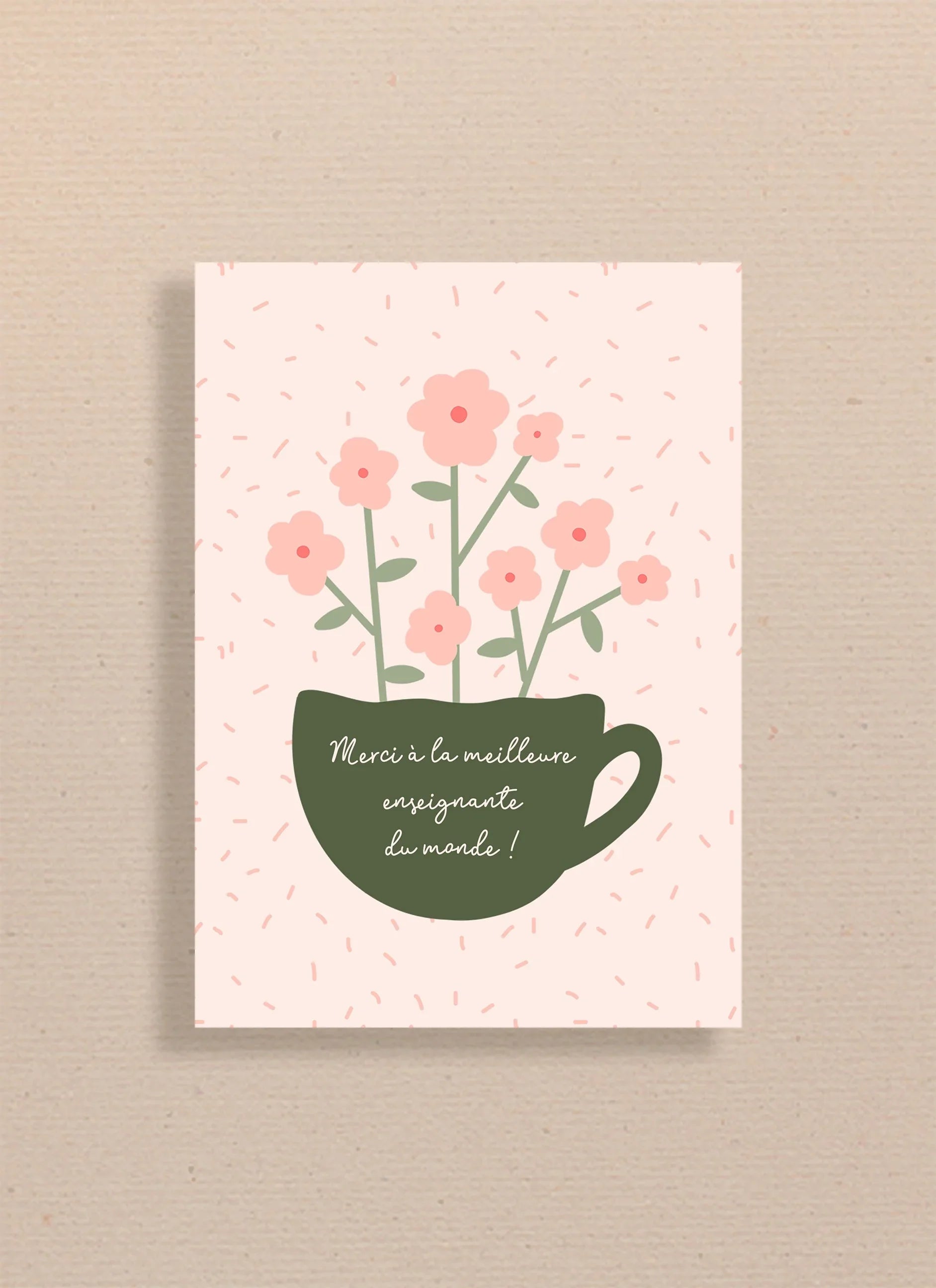 Carte avec tasse verte et fleurs roses, texte Merci à la meilleure enseignante du monde