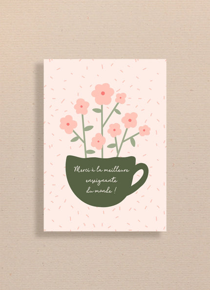 Carte avec tasse verte et fleurs roses, texte Merci à la meilleure enseignante du monde