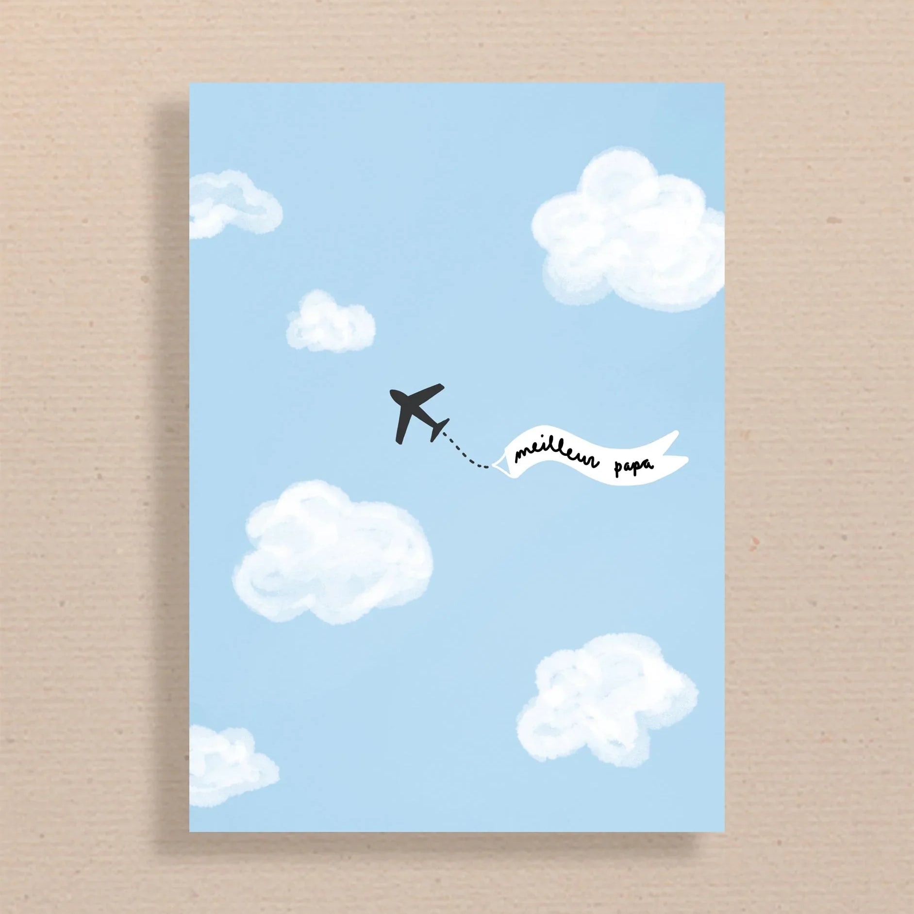 Carte bleue avec illustration avion noir tirant une bannière blanche "meilleur papa" dans un ciel avec nuages
