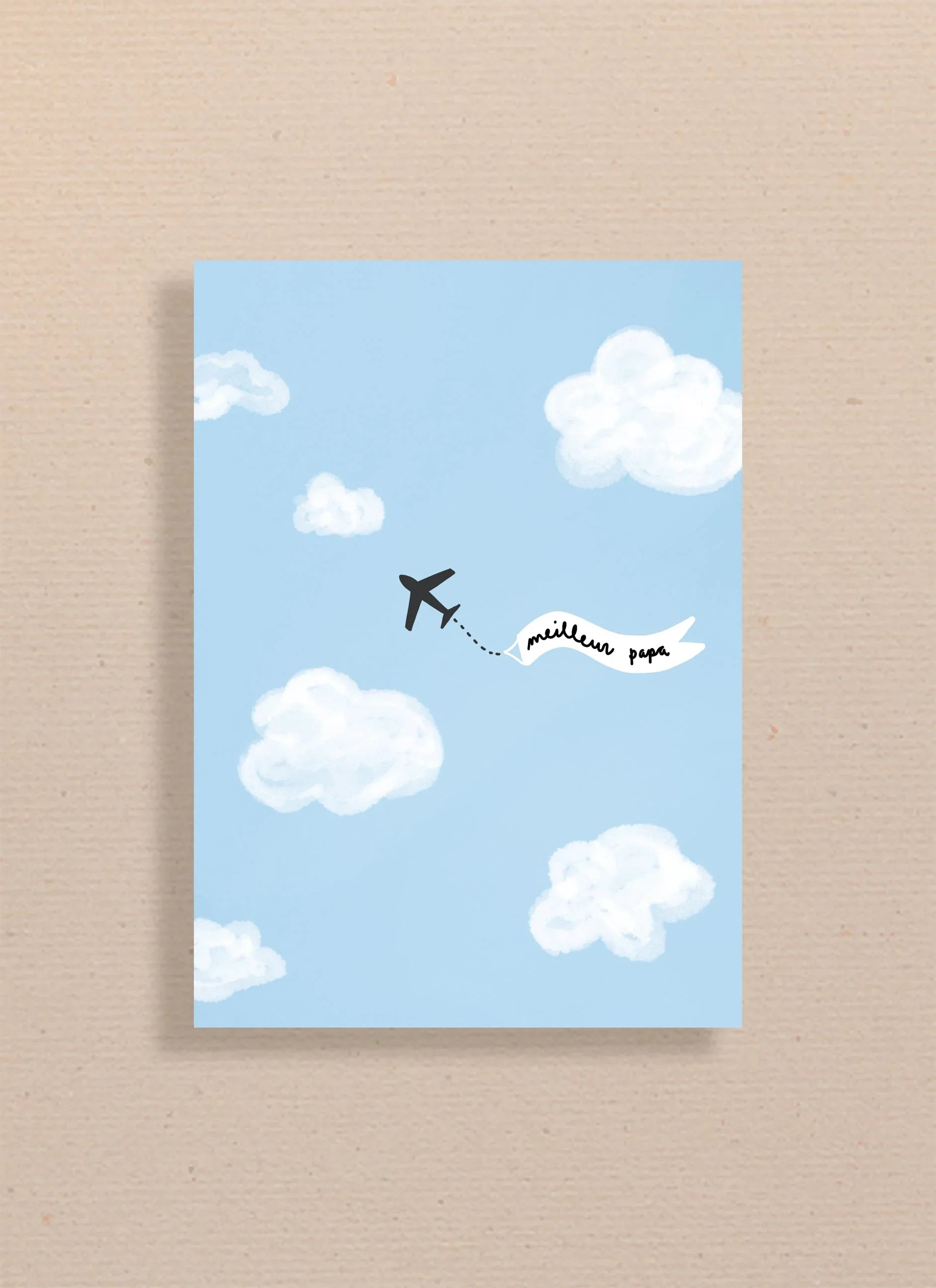 Carte bleue avec illustration avion noir tirant une bannière blanche "meilleur papa" dans un ciel avec nuages