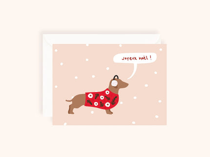 Carte de Noël illustrée avec chien portant un pull rouge à motifs floraux et cache-oreilles, fond beige avec flocons